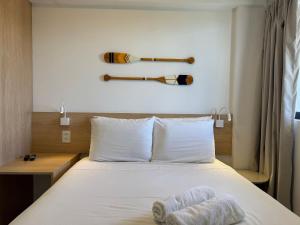 a bedroom with a bed with two baseball bats on the wall at Porto Kai Residence Flat Vila de Porto de Galinhas 50m do mar in Porto De Galinhas