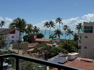 a view of a city with palm trees and the ocean at Porto Kai Residence Flat Vila de Porto de Galinhas 50m do mar in Porto De Galinhas