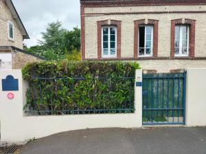 a gate in front of a house with a hedge at Appartement avec cour privée in Caen