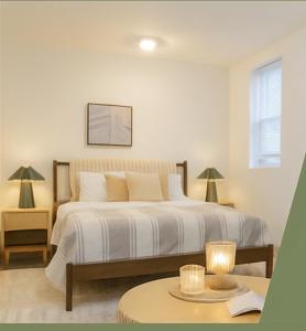 Un dormitorio con una gran cama blanca con una mesa. en Moderno 1BR - Parking - 15 min NYC, en Jersey City
