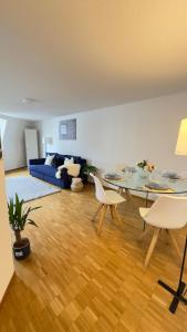 a living room with a table and a blue couch at Boho Bliss Apartments in Delémont