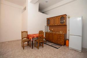 a kitchen with a table and chairs and a refrigerator at Hotel Anton Logu in Shkodër