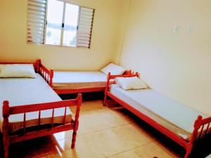 two twin beds in a room with a window at Bem Estar5 in Aparecida