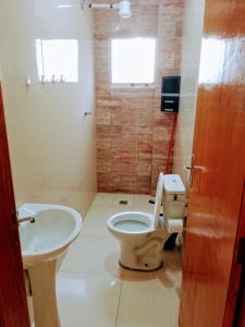a bathroom with a toilet and a sink at Bem Estar5 in Aparecida