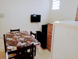 a dining room with a table and a tv on the wall at Bem Estar5 in Aparecida
