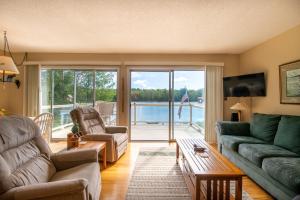 a living room with a couch and a table at Private Lakefront House On Peaceful Private Lake in Charlevoix