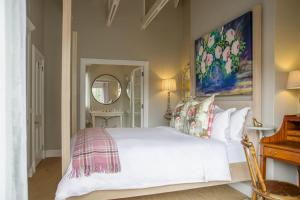 Un dormitorio con una cama blanca con un cuadro en la pared. en Charming Coastal Townhouse at The Majestic, en Ciudad del Cabo