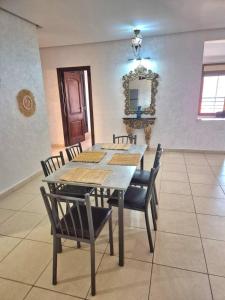 a dining room with a table and chairs and a mirror at Appartement 6 personnes piscine hivernage Marrakech in Marrakesh