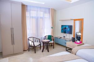 a hotel room with a bed and a table and chairs at Adeea Suites Naivasha in Naivasha +29 photos