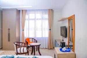 a room with a table and chairs and a window at Adeea Suites Naivasha in Naivasha