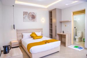 a bedroom with a large bed and a bathroom at Adeea Suites Naivasha in Naivasha
