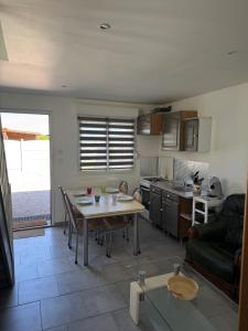 a kitchen and living room with a table and a couch at Le repaire 3 in Saint-Omer-Capelle +9 photos