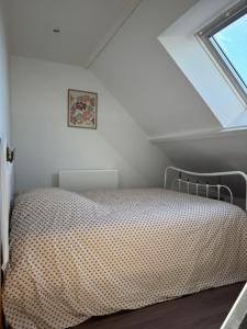 un letto in una stanza con una finestra di Le repaire 3 a Saint-Omer-Capelle