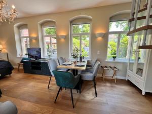 a living room with a table and chairs and windows at Charmantes Hinterhaus mit Terrasse - zentrale Lage in Dresden