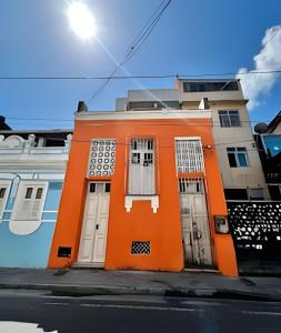 un edificio arancione con porte bianche su una strada di UNU Santo Antônio Além do Carmo - Amplo, varanda + a Salvador