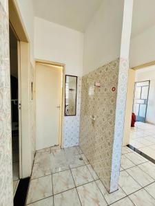 a bathroom with a shower and a tile floor at Apartamento mobiliado em Contagem - 2 quartos in Contagem