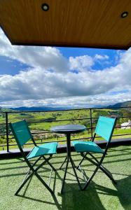 two chairs and a table on a balcony with a view at Terra Alta Mirador in La Calera +6 photos
