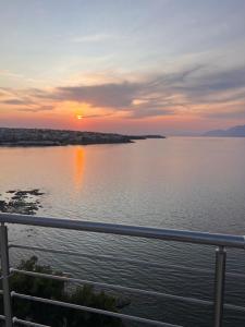 a sunset over a body of water with a fence at OpenSea #2 in Chalkida