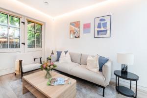 una sala de estar con un sofá y una mesa en Modern 1 bed House in Kensington High St, en Londres
