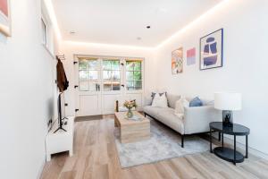 una sala de estar con un sofá y una mesa en Modern 1 bed House in Kensington High St, en Londres
