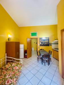 ジャルディーニ・ナクソスにあるLina Houseのベッド、テーブル、キッチンが備わる客室です。