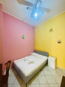 ジャルディーニ・ナクソスにあるLina Houseのベッドと天井扇風機のある寝室