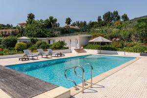 a swimming pool with chairs and an umbrella at HostWise - Modern Villa & Shared Pool in Paredes in Vandoma +26 photos