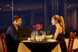 a man and woman sitting at a table in a restaurant at PortoBay Rio de Janeiro in Rio de Janeiro