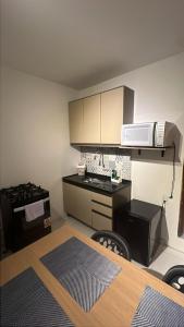a small kitchen with a stove and a microwave at Apto inteiro no centro de caruaru para 2 pessoas in Caruaru