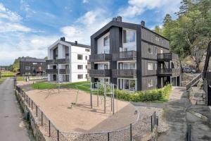 Un edificio de apartamentos con un parque infantil enfrente. en Åros Modern Apartment, en Kristiansand
