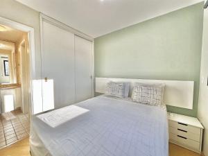 a bedroom with a large bed with white sheets and pillows at Maison D Stan Moema with washing machine and daily cleaning in São Paulo +26 photos