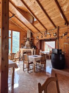 a dining room with a table and chairs in a cabin at Hotel Melishta in Peje