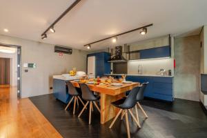 a kitchen with a wooden table and blue cabinets at HostWise - Modern Villa & Shared Pool in Paredes in Vandoma