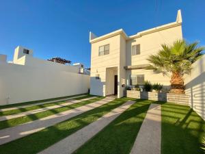 una casa blanca con una palmera delante en F8 Private Pool Handicap access, Fiber Optic WiFi, en Puerto Peñasco