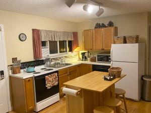 a kitchen with a white refrigerator and a table at Private Lakefront House On Peaceful Private Lake in Charlevoix +17 photos