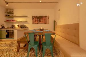 a dining room with a table and two green chairs at Castillo Grande Bayside Retreat 6BR 2 Homes in Cartagena de Indias +67 photos