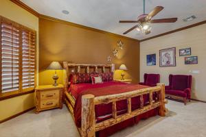 a bedroom with a wooden bed and two red chairs at Goodyear Greetings in Goodyear +18 photos