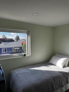 un dormitorio con una cama y una ventana en Departamento Studio Full 109, en Osorno