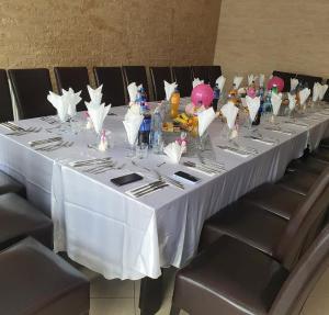 a long table with a white table cloth and chairs at Pensiunea Vila Maria in Crăcăoani +75 photos