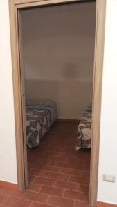 Habitación con 2 camas y puerta a un dormitorio en Rifugio nel borgo, en Monasterace