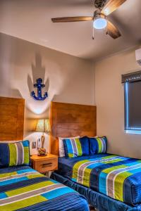 Un dormitorio con dos camas y una mesa con lámpara. en L15 Modern Private Pool Home, en Puerto Peñasco 44 fotos más