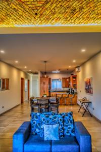 Una sala de estar con un sofá azul y una cocina. en L15 Modern Private Pool Home, en Puerto Peñasco
