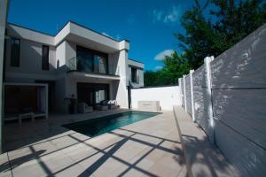 a house with a swimming pool next to a fence at Mi Casa 2 in Vrdnik