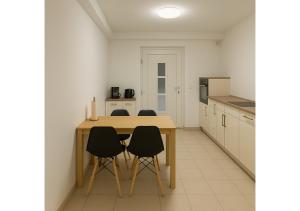 a kitchen with a wooden table and four chairs at Erft Apartment in Kerpen
