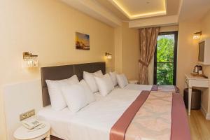 a hotel room with a large bed with white pillows at Grand Naki Hotel in Istanbul