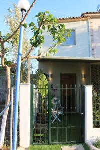 a green fence in front of a house at Cosy Paradise in Palouki