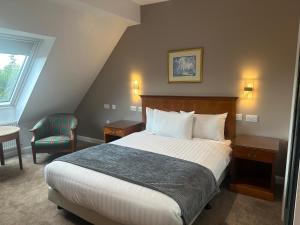 a hotel room with a bed and a chair at Desalis Hotel London Stansted in Elsenham +51 photos