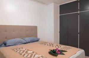 una camera da letto con un letto con un fiore rosa di Studio Teava a Papeete
