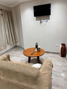 a living room with a table and a tv on the wall at Como en casa in Aguilares