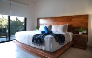a bedroom with a large bed with a blue ribbon on it at Casa Vibe PH- Private Rooftop - 3 Balcony - Pool in Tulum +82 photos